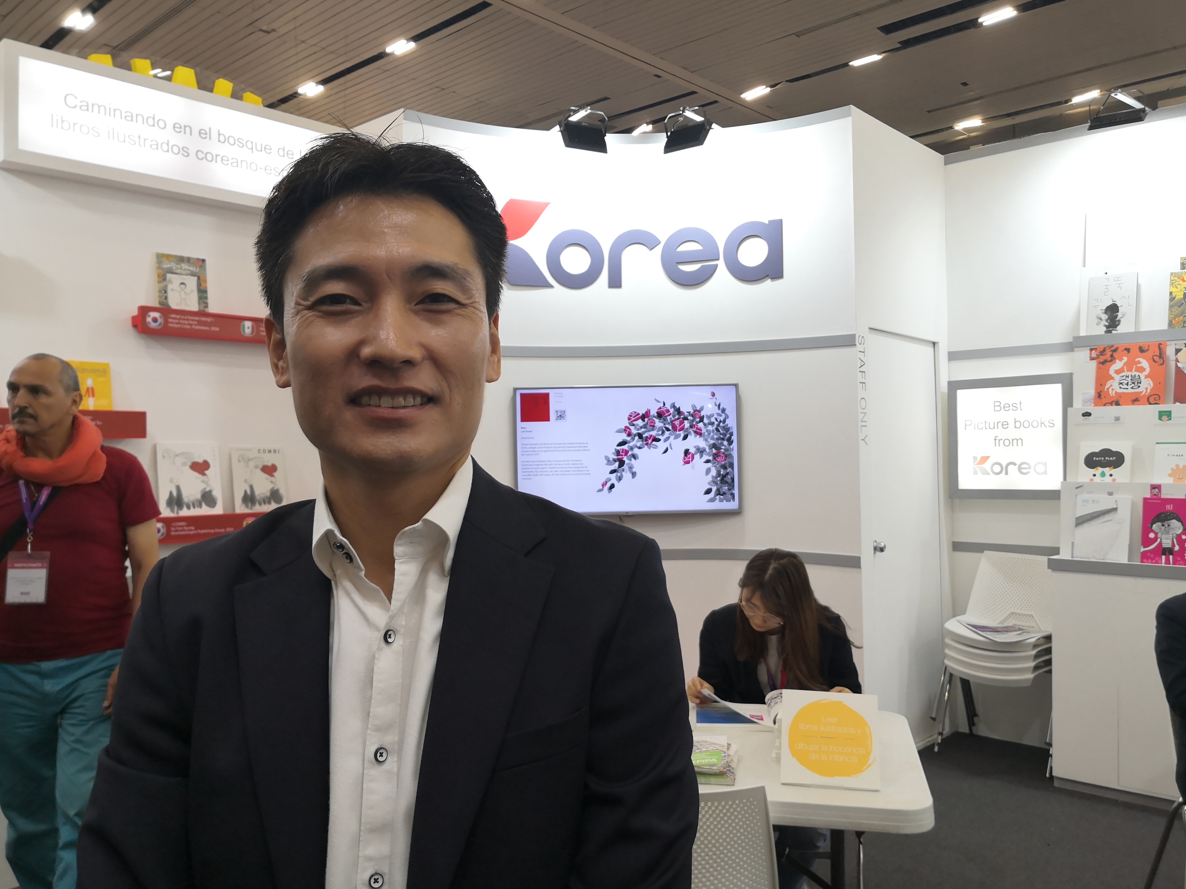 Robin Kim de Agencia de la Promoción de la Industria de Publicaciones de Corea habla frente de Espacio de exposición de KPIPA en la Feria Internacional del Libro de Guadalajara 2019. 