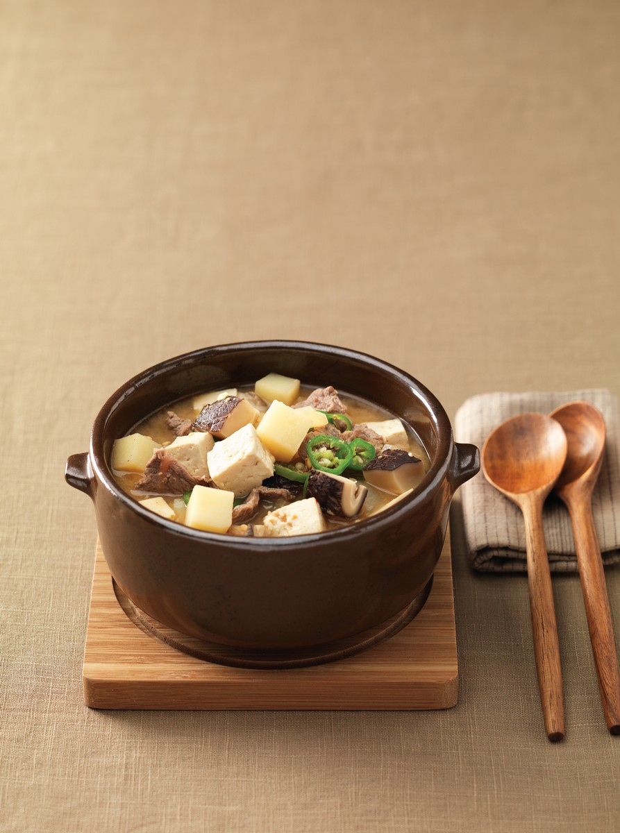 Doenjang Jjigae (Soybean Paste Stew). This stew-like Korean dish is made by boiling an assortment of ingredients such as meat, clams, vegetables, mushrooms, chili, tofu, and soy paste.