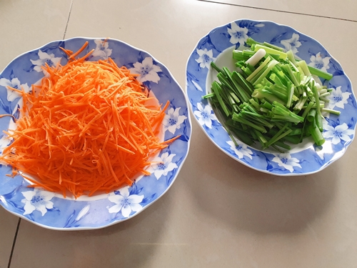 Bào nhỏ cà rốt và cắt khúc hành, hẹ vừa ăn trước khi tiến hành làm xốt ướp Kimchi dưa chuột. (Ảnh: Vũ Đỗ Hải Hà)