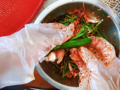 Chà xát đều từ trong ra ngoài xốt ướp Kimchi lên dưa chuột. (Ảnh: Vũ Đỗ Hải Hà)
