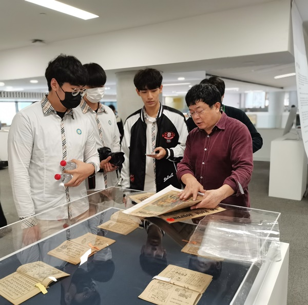 香港中文大学（深圳）驻校艺术家邓康延先生（左）向中国深圳韩国国际学校的同学们介绍展品。韩宣网记者白若晶 摄