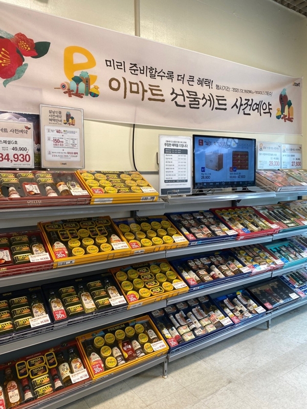 韓国の大型マートであるＥマートの名節ギフトコーナー、事前予約の案内。定番の缶詰めセットや油のセットが並ぶ。