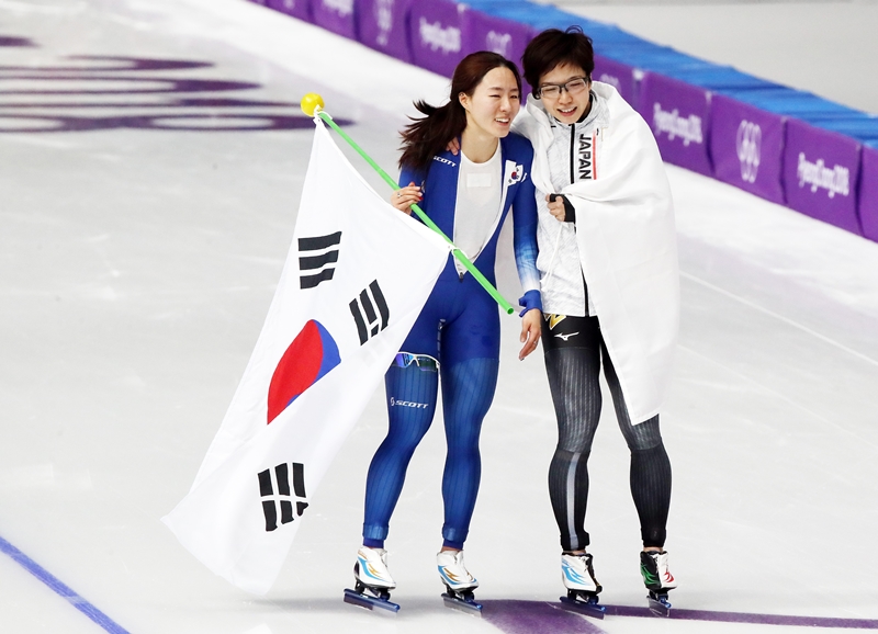 ２０１８年平昌冬季五輪のスピードスケート女子５００メートルが終わった後、競技場を回っている李相花（左）と小平奈緒＝２０１８年２月１８日、江原道・江陵、聯合ニュース