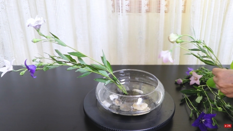 Bàn ghim được đặt chìm vào lọ cắm để hỗ trợ nghệ nhân cố định hoa, lá, cành trong nghệ thuật Kkochkkoji (Ảnh: Chụp màn hình từ video trên trang Youtube của Jenna’s Flower Garden)