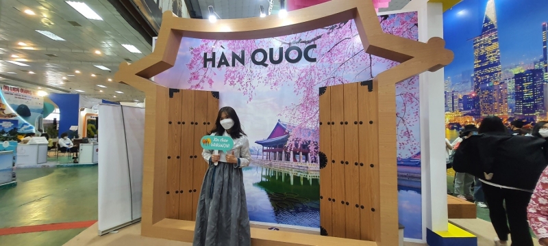 Du khách trải nghiệm mặc đồ Hanbok tại gian hàng du lịch Hàn Quốc. (Ảnh: Bùi Thái Hường)