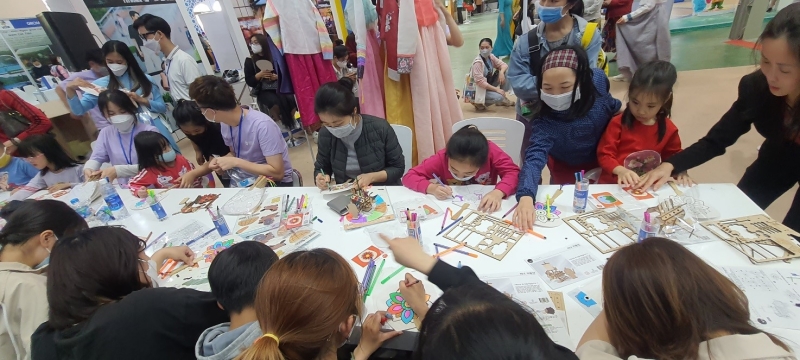 Gian hàng làm đồ thủ công Hàn Quốc như tô màu quạt giấy, lắp ghép mô hình thu hút được sự quan tâm từ các em thiếu nhi cho đến các bậc phụ huynh. (Ảnh: Bùi Thái Hường)