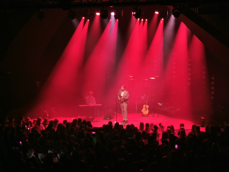 Rhys Lewis chante avec sa guitare électrique en main au côté d’un pianiste © Lei Léa Chi