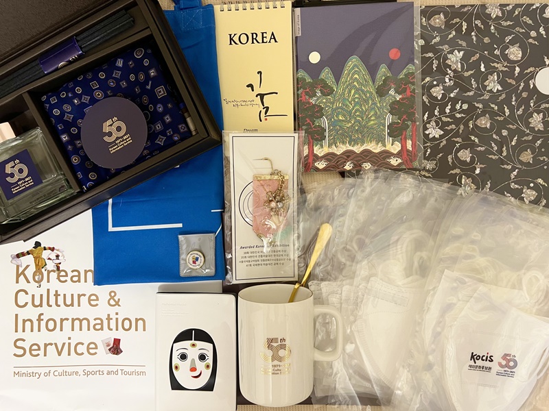 お土産でいただいた、KOCIS50周年の記念品など〜螺鈿細工模様のクリアフォルダ。ルームパフュームセット。たっぷりマスク。肩掛けが長くて便利そうなハングルエコバック。ノリゲ。日月五峰図ノートと夢ノート。パスポートカバー。マグカップ＆スプーン。名誉記者団バッヂなどなど！