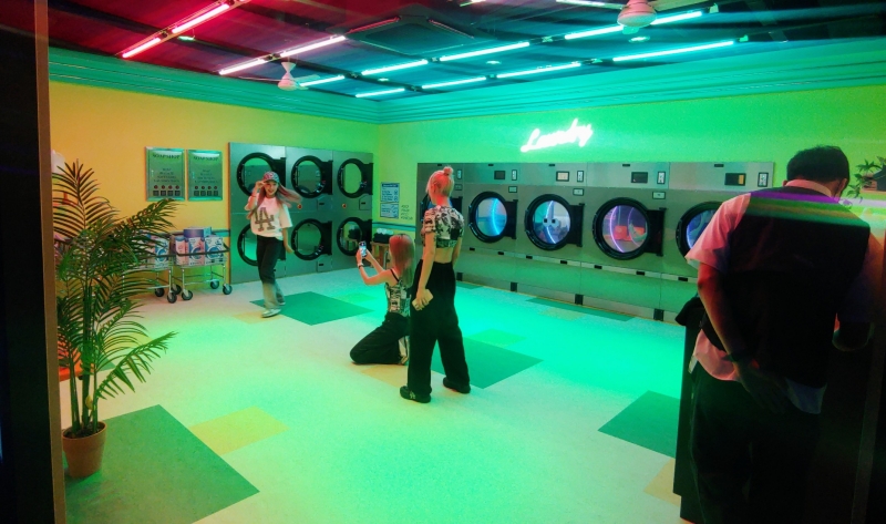 Các dancer đang thực hiện các cảnh quay tại studio concept máy giặt tiền xu mang nét bình dân nhưng đậm nét đặc trưng của Hàn Quốc tại tầng 2 của HiKR Ground. (Ảnh: Phạm Thị Bích Nguyệt)