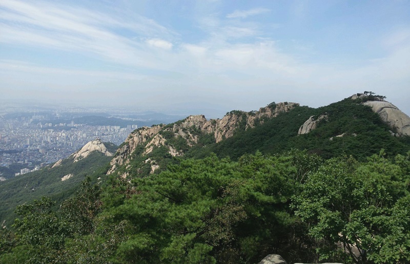 北漢山。後ろに見えるのはソウルの全景＝国立公園公団