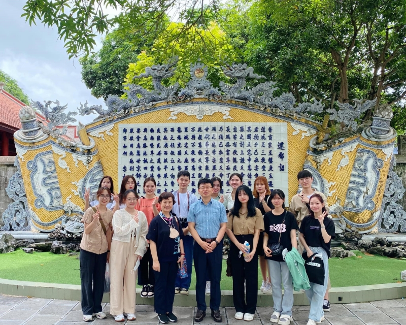 Ông Lee See Young, cô Lee Kye Sun và các bạn sinh viên chụp ảnh lưu niệm tại di tích đền Đô, Bắc Ninh. (Ảnh Đặng Xuân Dương)