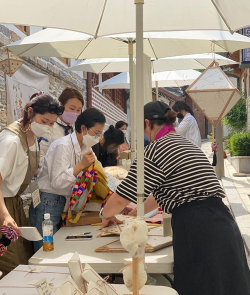 La artista e instructora Kim Jiyeon junto con su equipo de trabajo enseña el arte de Bojagi en los mercadillos en Seúl.