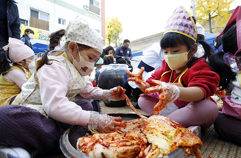 Unas estudiantes de preescolar ayudan a preparar kimchi en un programa de voluntario llevado a cabo el pasado 15 de noviembre en el centro comunitario en el vecindario Unam-2dong del distrito Buk-gu de la ciudad de Gwangju. | Oficina del distrito de Buk-gu, Gwangju