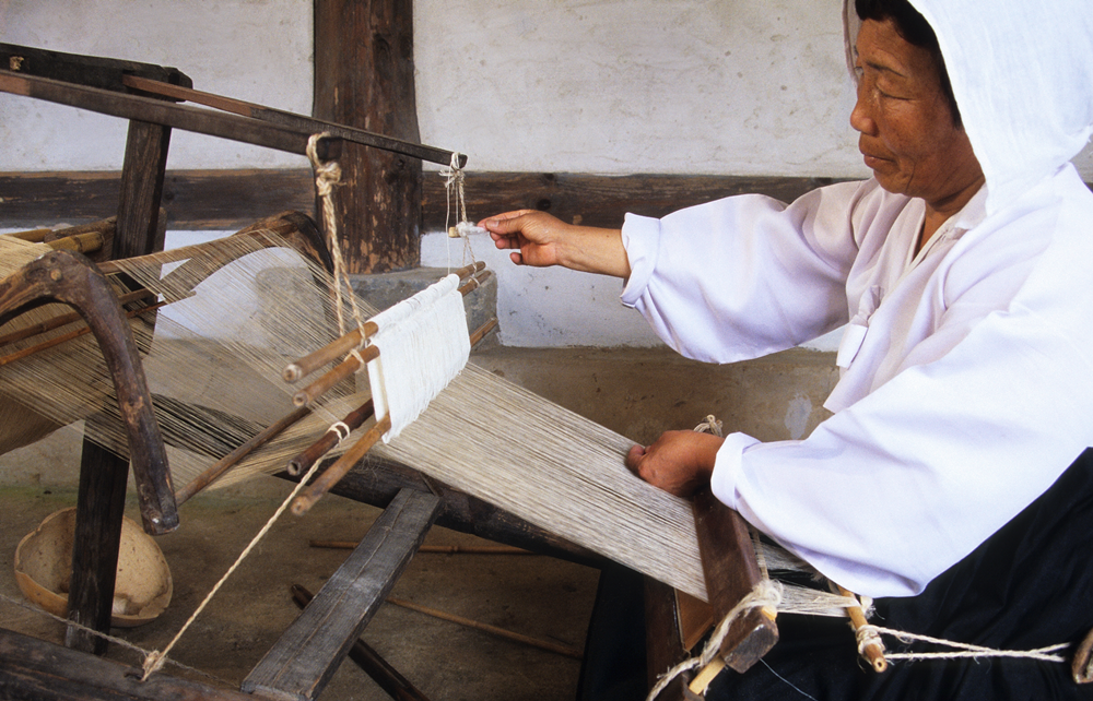 La foto muestra a una coreana haciendo un tejido de Mosi. | Página web oficial de la Administración del Patrimonio Cultural
