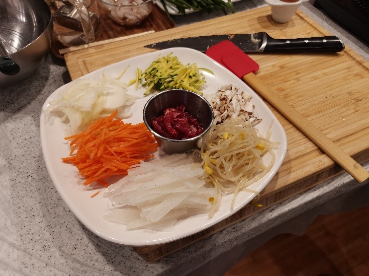 把胡瓜、香菇、黄豆芽、白萝卜、胡萝卜和洋葱切丝摆好，再依次炒熟。韩宣网名誉记者白若晶 摄