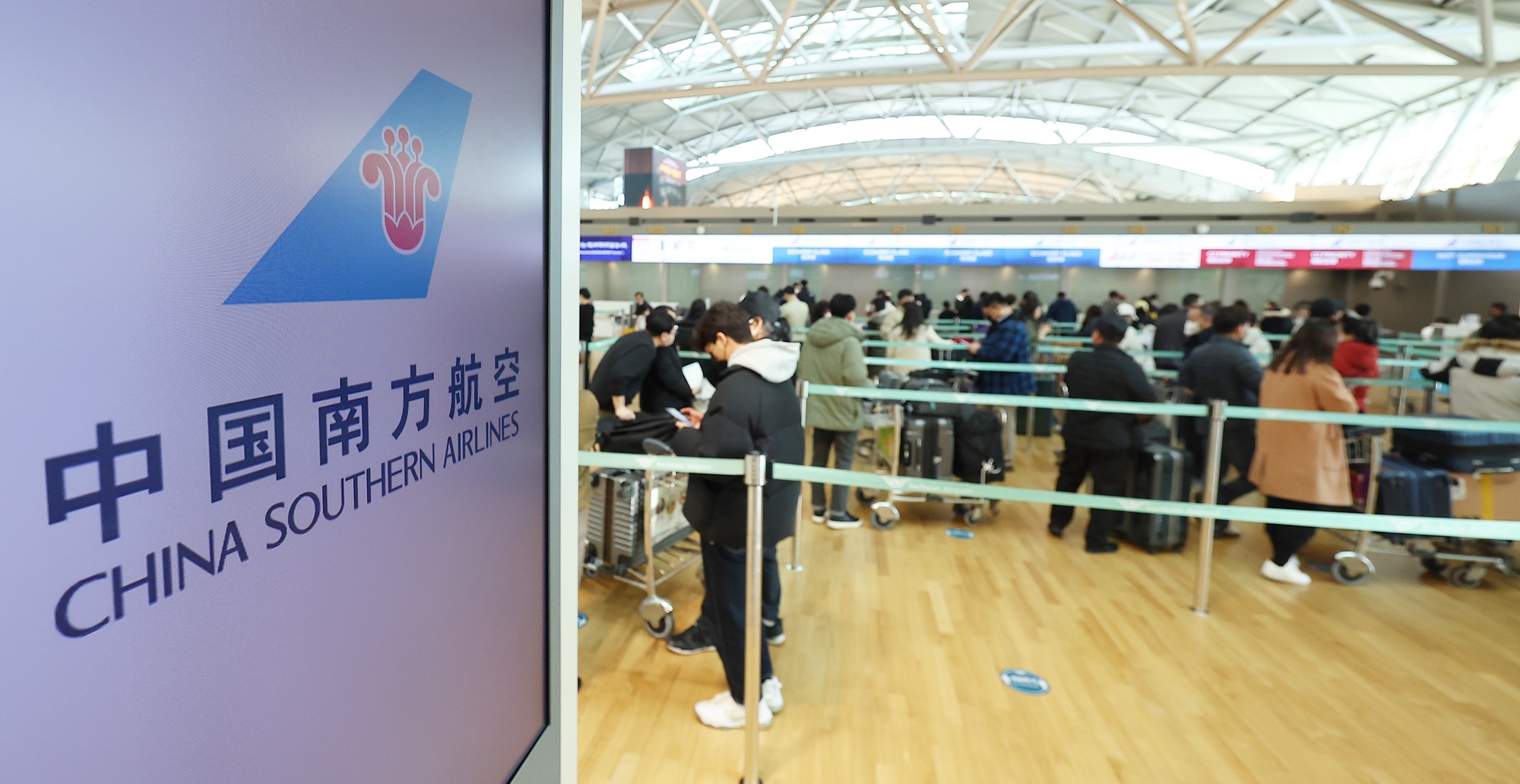 From March 1, the mandatory PCR test on arrival for incoming travelers from China will be lifted. Shown is a group of passengers waiting for the boarding process to depart for China in the departures section of Incheon International Airport's Terminal 1. (Yonhap News)