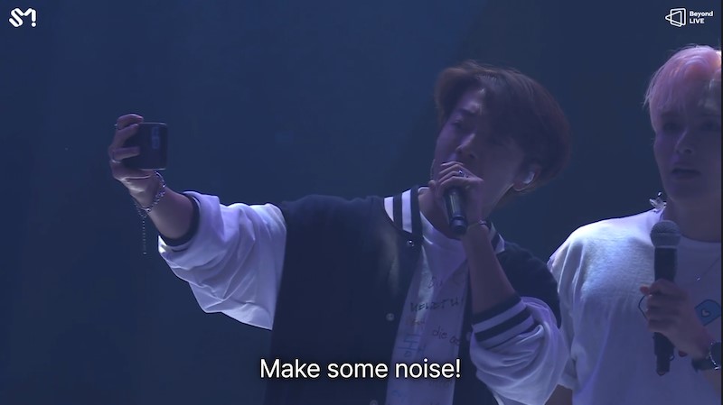 Après presque trois heures et demie d'interprétation, Donghae et Ryeowook animent la foule une dernière fois pour capter les souvenirs dans une vidéo. © Marla Arbach – Capture d’écran lors de la diffusion du concert sur Beyond Live. 