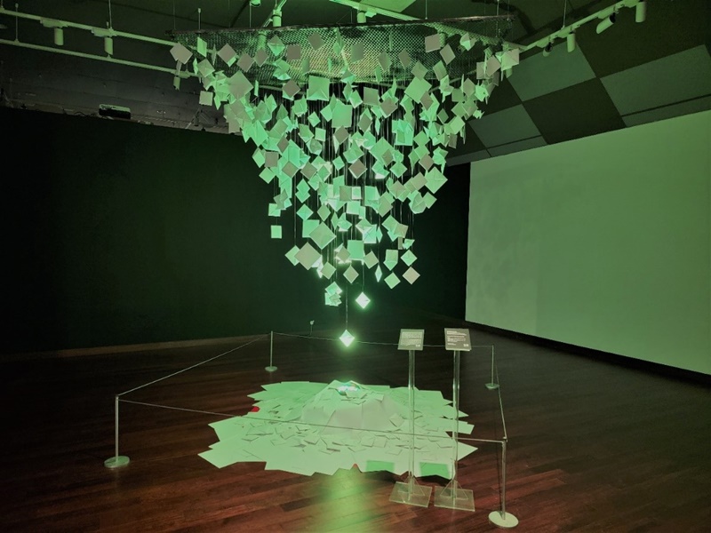  图为在2023年马来西亚韩流展览会在现场拍到的装置艺术作品——《Mastermind：Flipped The Mind》，该作品的特点是在灯光下盘旋在空中的闪闪发光的画片。韩宣网名誉记者张欣蕾 摄