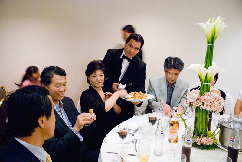 Invitados coreanos comiendo tequeños, aperitivo típico del país, en una boda realizada en Venezuela. | Lee Suwon