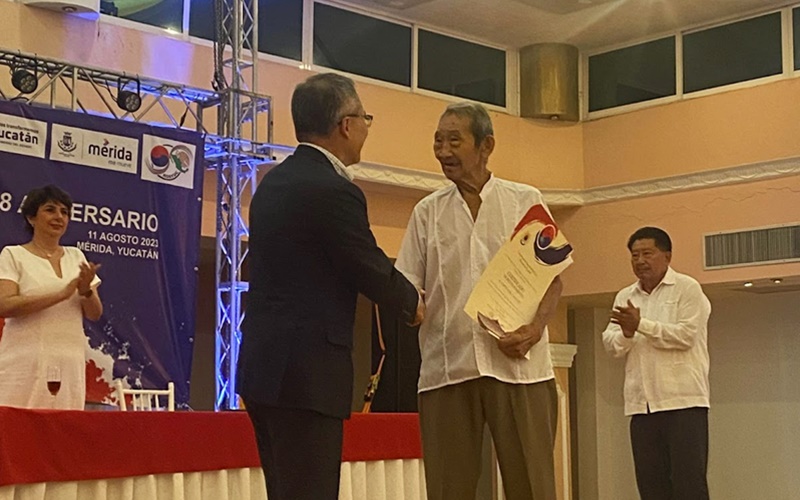 El embajador de la Corea del Sur en México, Huh Tae Wan, hace entrega del reconocimiento a Sixto Kim, un descendiente de segunda generación.