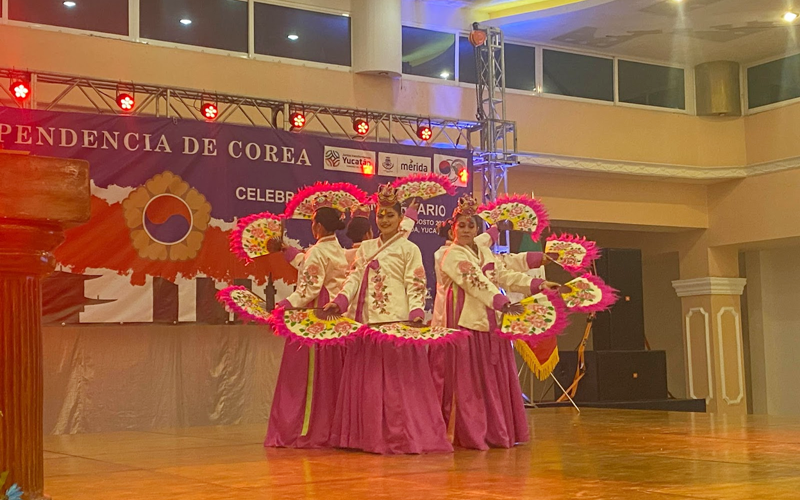 La foto muestra la presentación de la danza de los abanicos, conocida como buchaechum, a cargo del grupo Ballet Kaambal.