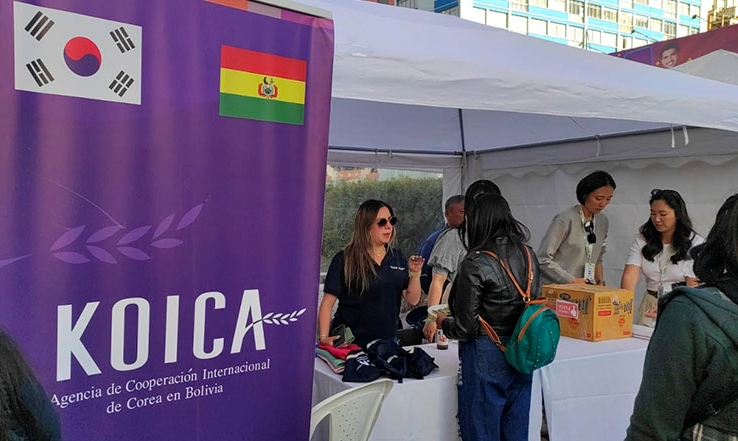 Una encargada de la KOICA en Bolivia atendie una asistente en la feria.