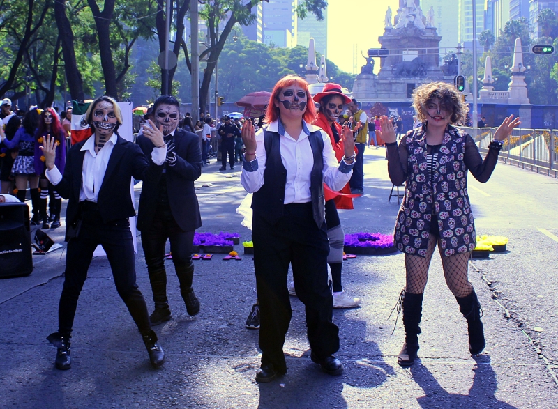 Unos jóvenes mexicanos, maquillados como catrín y catrina, se presentan bailando a ritmo de K-pop en la mega procesión de catrinas 2023, celebrada el 22 de octubre en la Ciudad de México.