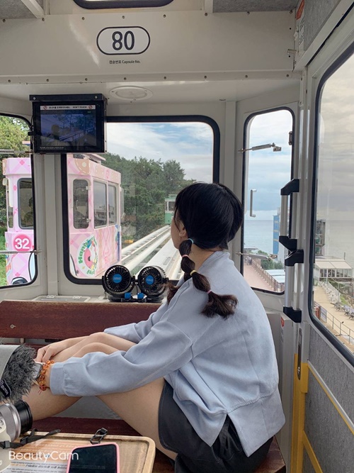 图为坐在“天空胶囊火车”的笔者正在观赏窗外釜山美丽的海岸线。韩宣网名誉记者陈虹儒 摄