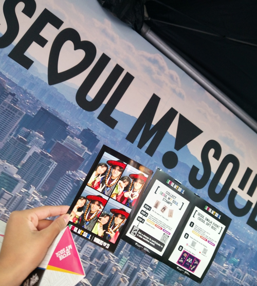 La foto muestra la fotografía impresa y el bloque de ddakji del estand 'Seoul my Soul'. 