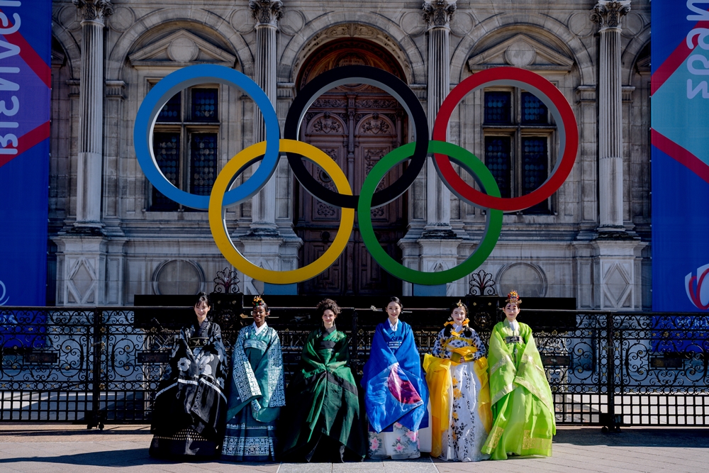 Les gagnantes du concours France-Corée devant le symbole des Jeux Olympiques qui auront lieu à Paris cette année.