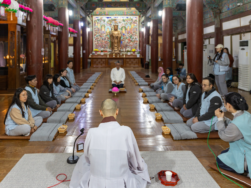 Los participantes escuchan las indicaciones de la práctica de las 108 postraciones, realizada dentro del salón Museoljeon del templo Bulguksa. | KOCIS