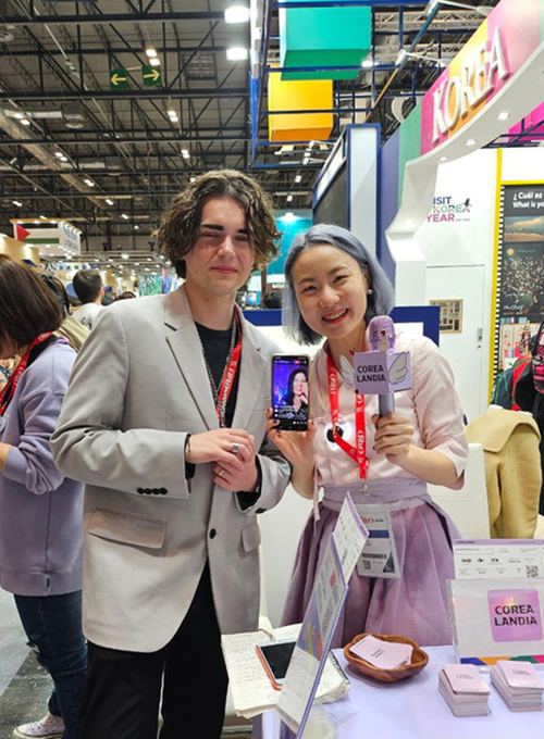 La directora general de Corealandia, Elena Jang (derecha), y el influencer Joel Sánchez Barbero de España, realizan un en vivo en Instagram con la representante de una agencia de viajes de Venezuela, durante la 44ª edición de la Feria Internacional de Turismo (FITUR).