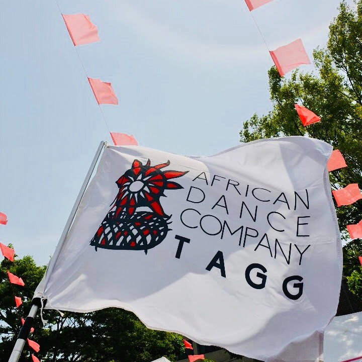 Drapeau de la compagnie de danse TAGG sur lequel peut être reconnu le dessin d'un nid.