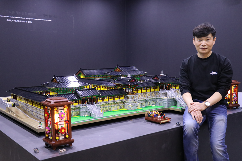 El artista Seunghwan Yang se toma una foto junto con el diorama del templo Bulguksa, creado con 50.000 ladrillos.