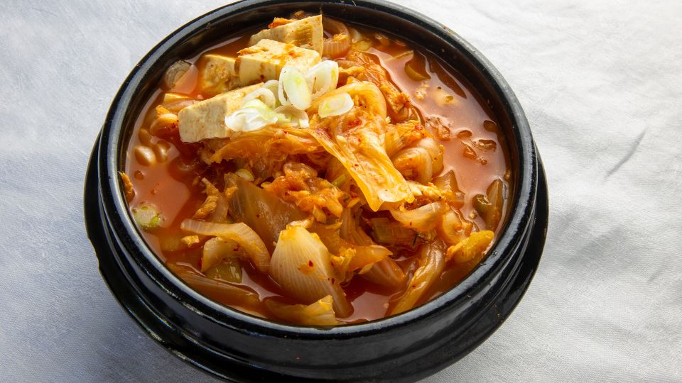 El chamchi kimchi jjigae es un estofado de kimchi, atún en lata y tofu muy sencillo de preparar que se disfruta junto con arroz y guarniciones coreanas. | Canva Pro