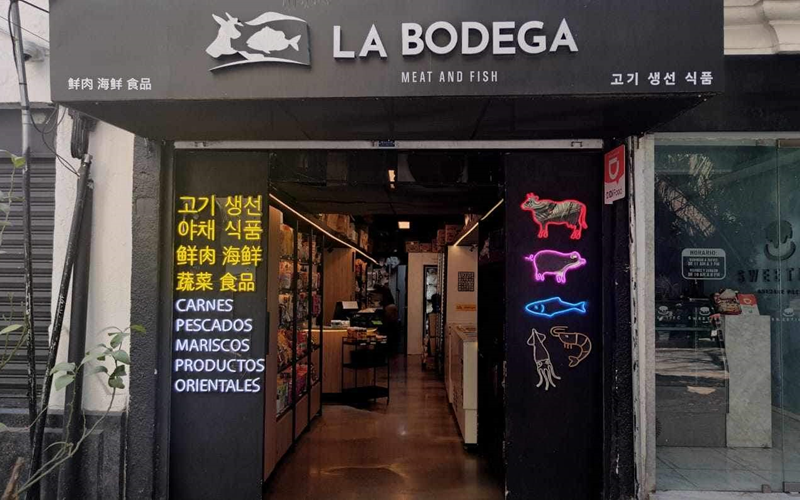 La foto muestra la entrada del restaurante coreano 'La Bodega'. 