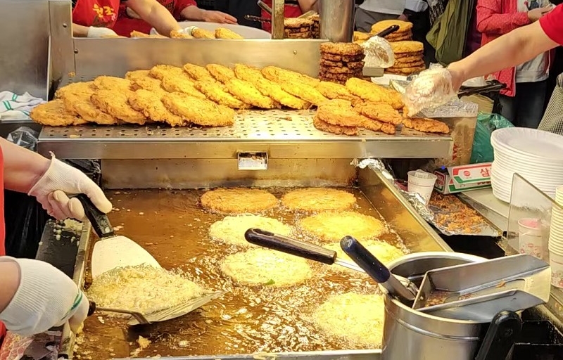 La foto muestra un puesto de panqueques a base de frijol mungo en el mercado Gwangjang en Seúl. Los mismos se preparan y cocinan en el momento.