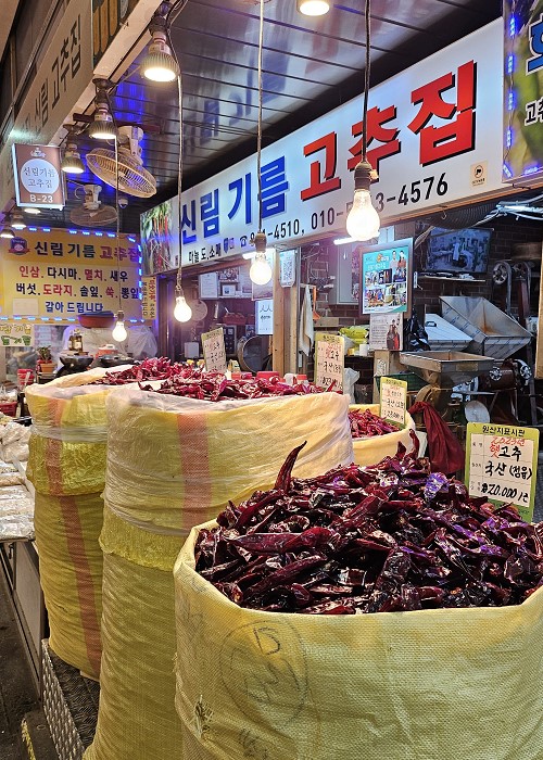 La foto muestra una tienda de chiles secos en el mercado Sinwon en Seúl. El chile rojo, llamado gochu en coreano, es un elemento muy importante para la gastronomía coreana.