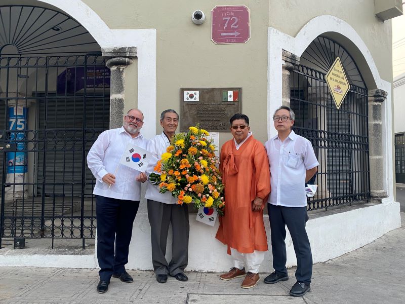 Los miembros de KORYUC posan con una ofrenda floral al memorial por la inmigración coreana en Yucatán, Chemulpo.