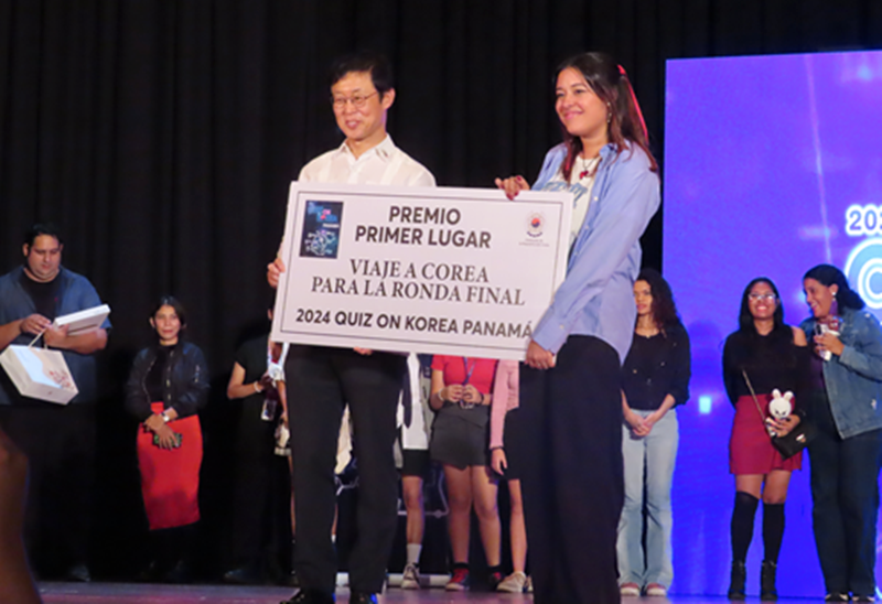 La ganadora del primer lugar del concurso 'Quiz on Korea Panamá' (derecha) se toma una foto conmemorativa con el embajador de Corea en Panamá, Jeong Jinkyu. 