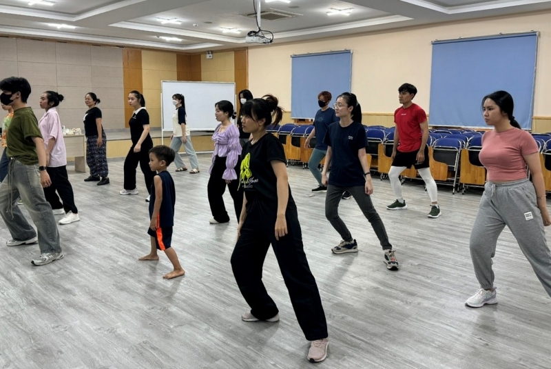 Dưới sự hướng dẫn của Thầy Duy (áo màu xanh rêu), mọi người đang học cách chuyển động giúp cơ thể uyển chuyển hơn khi nhảy. (Ảnh: Trang Facebook của Trung tâm Ngôn ngữ tiếng Hàn tại Thành phố Hồ Chí Minh)