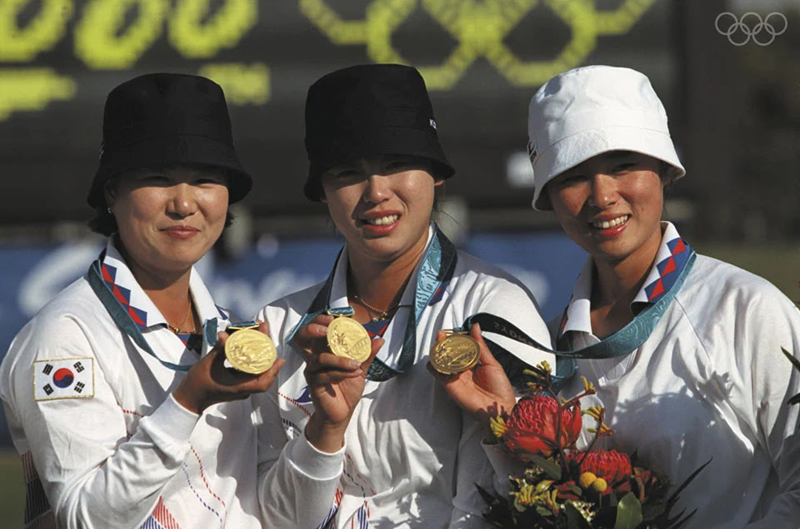 Las integrantes del equipo femenino de arquería de Corea, lucen sus medallas de oro, durante la ceremonia de premiación de los Juegos Olímpicos de Sídney en 2000. | Comité Deportivo y Olímpico de Corea 