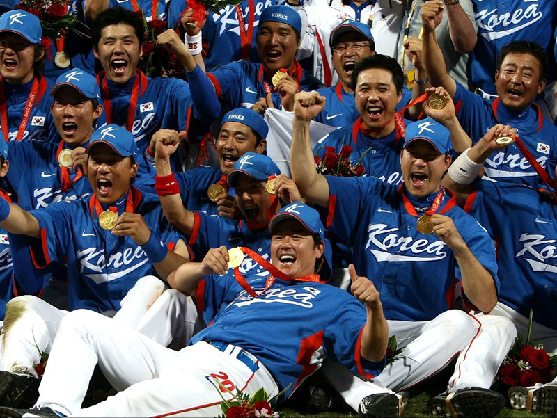 El equipo de béisbol de Corea celebra su triunfo, luego de recibir las medallas de oro, durante los Juegos Olímpicos de Beijing en 2008. | Confederación Mundial de Béisbol y Sóftbol 