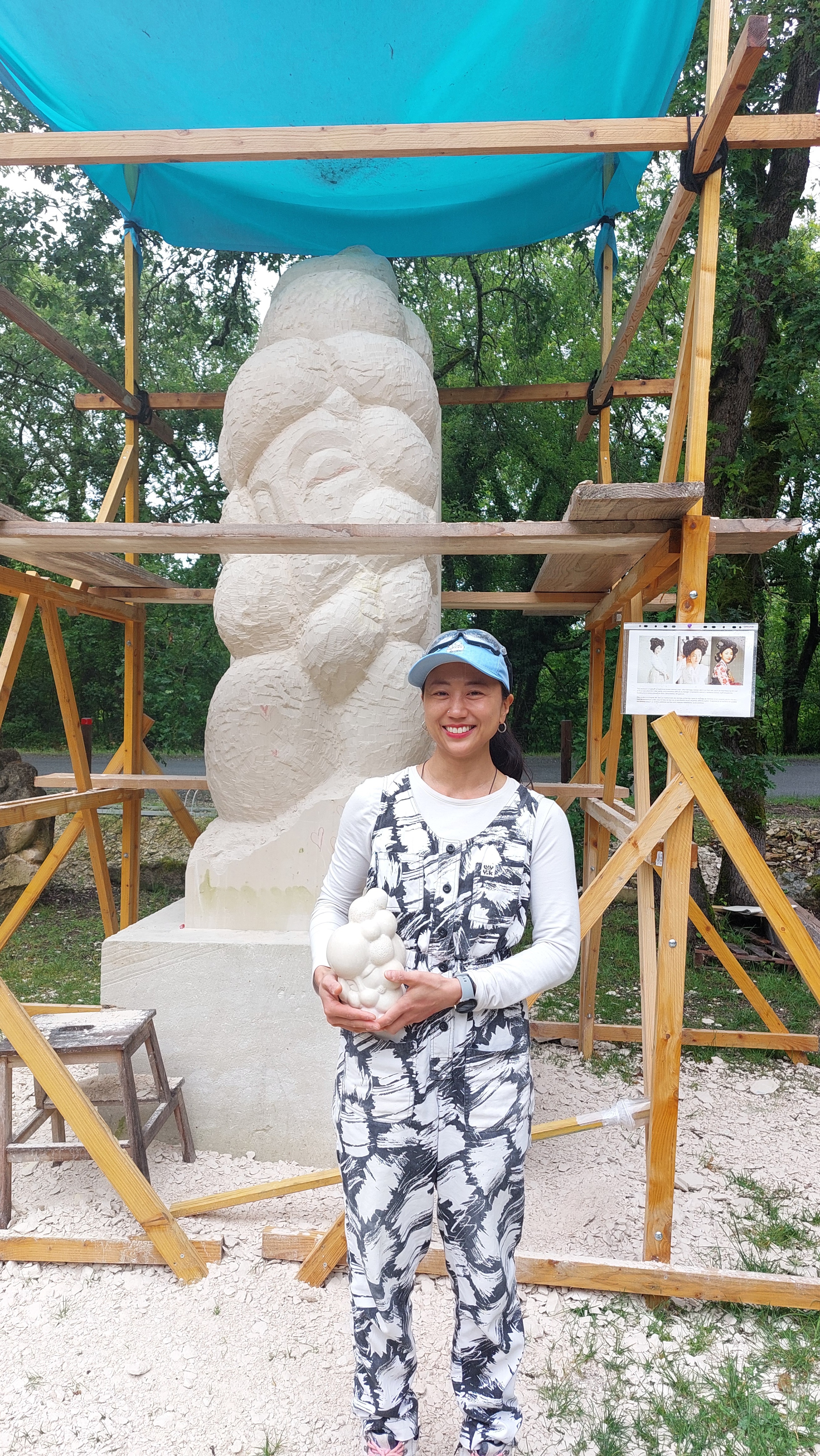 La sculptrice coréenne Lee Jina posant devant son œuvre en cours de création aux Lapidiales, en Charente-Maritime. © Emma