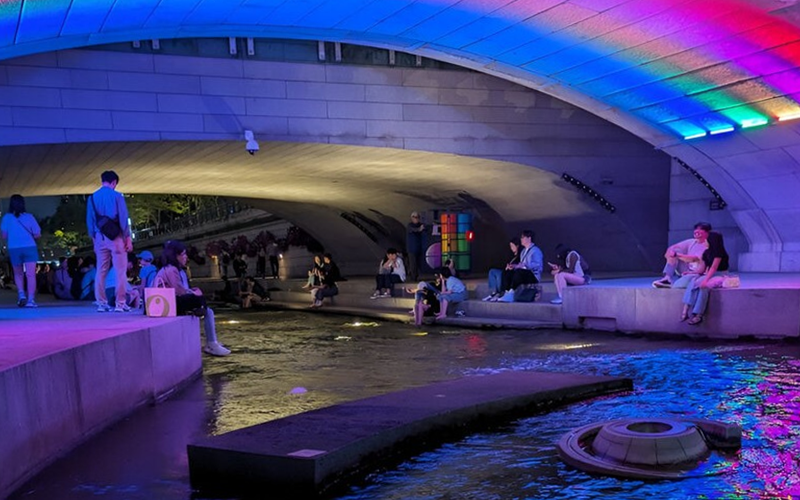 La foto muestra a los turistas descansando en el arroyo Cheonggyecheon, en el distrito de Jongno-gu, en Seúl. 