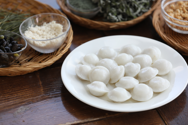 La foto muestra varios pasteles de arroz, conocidos como songpyeon, los cuales son rellenados con frijoles dulces y preparados al vapor. Estos pasteles se consumen tradicionalmente durante el Chuseok (fiesta de la cosecha). | Korea.net DB