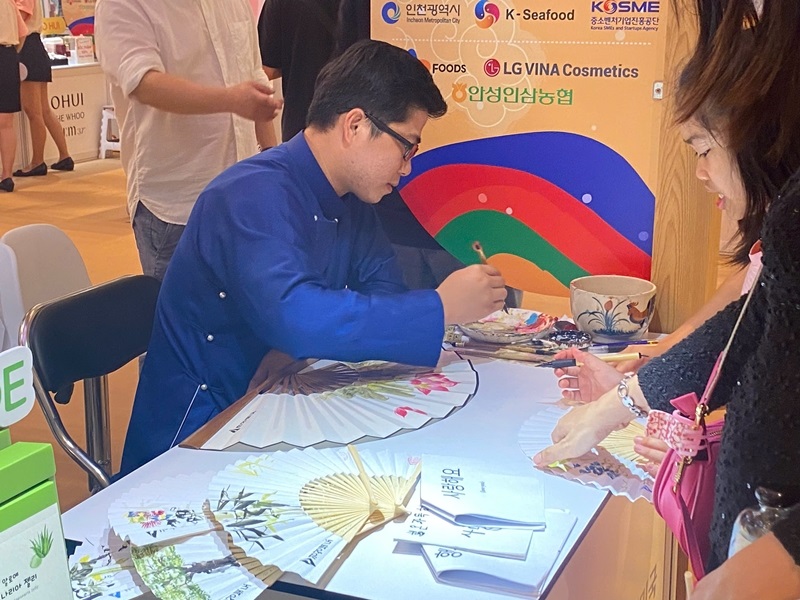 Một trong những gian hàng “đắt khách” nhất là gian hàng trang trí quạt giấy cầm tay bằng chữ thư pháp tiếng Hàn. (Ảnh: Phạm Thị Hà Phương)