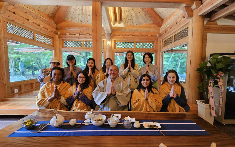 Los ganadores del tour se toman una foto con un monje budista durante la ceremonia de té en el Templo Daeheungsa.