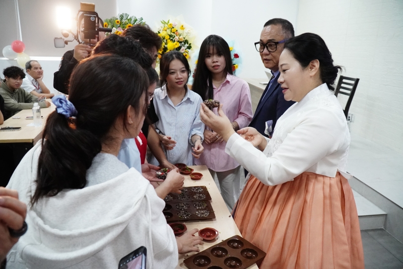 Cô Jo chia sẻ lại cách làm bánh Oranda đến từng nhóm sinh viên trải nghiệm. (Ảnh: Lê Thị Yến)