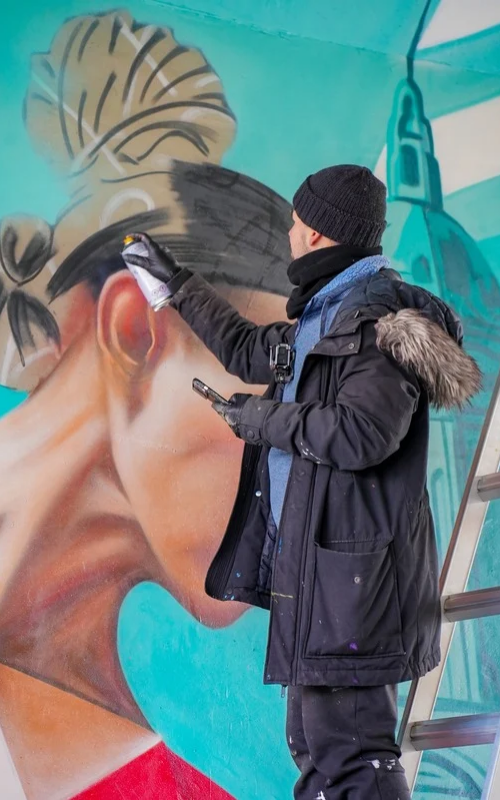 Fabián Bravo “KATO” en plena realización del mural
